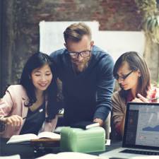 A man and two women around a data looking at data