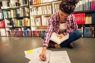 A woman making notes on a Suffolk library floor.