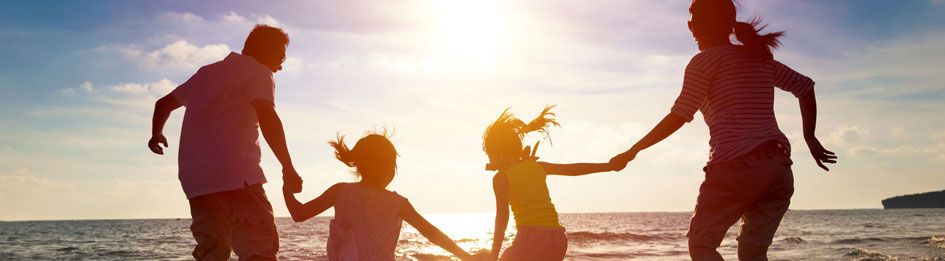 A family holding hands in the sunset at a Waterside Holiday Group resort.